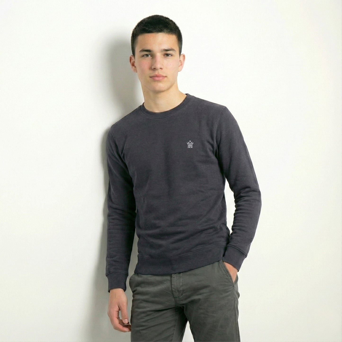 Man wearing a dark gray long-sleeve shirt against a white background