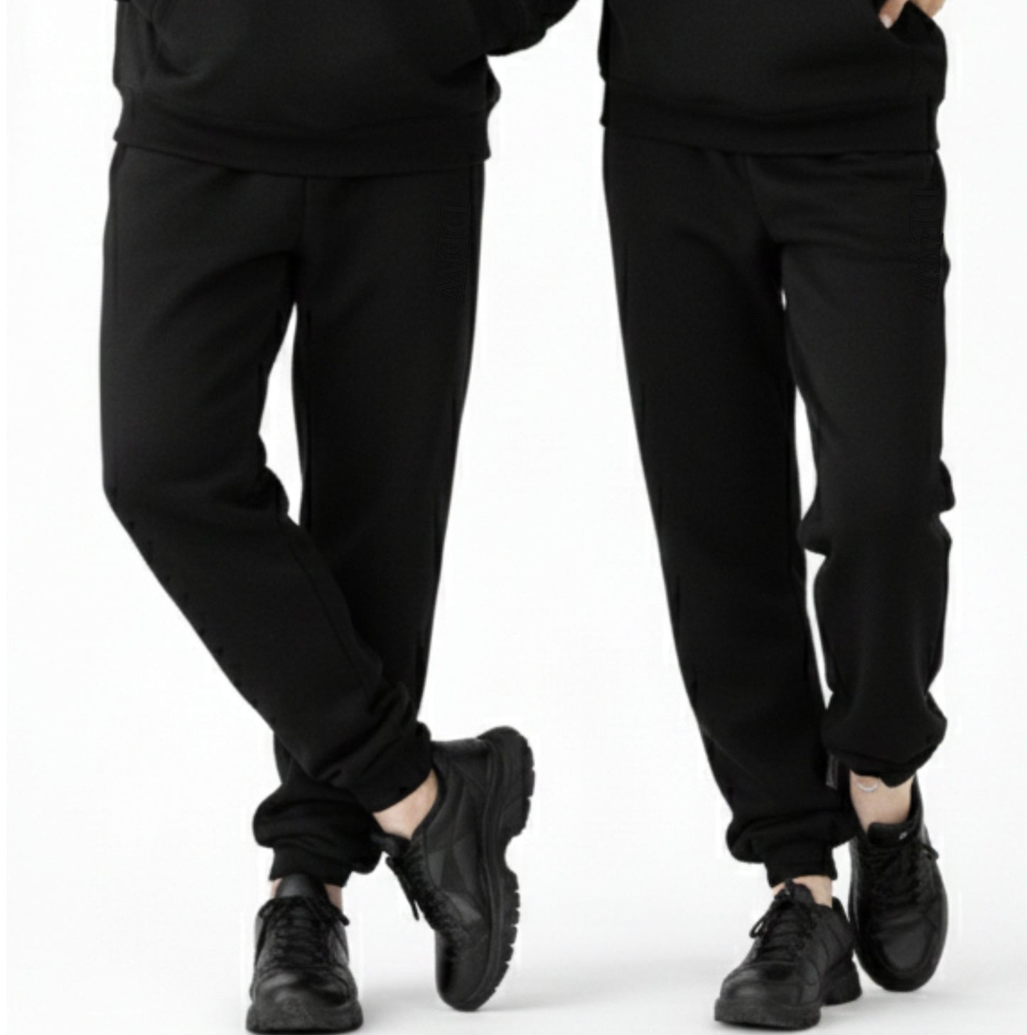Two pairs of black pants worn by people on a white background