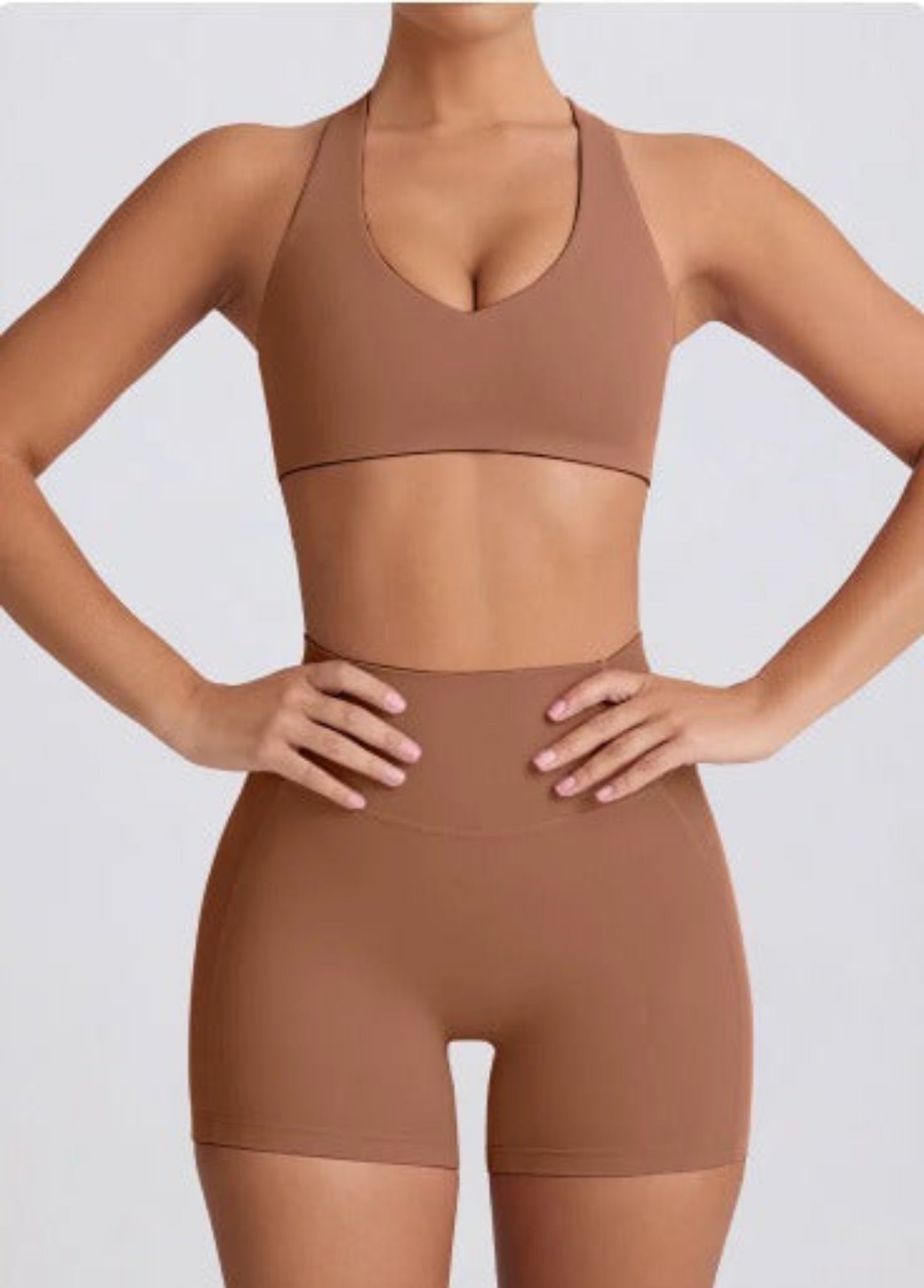 Person wearing a coco Dew heart flex bra and shorts set on a light gray background