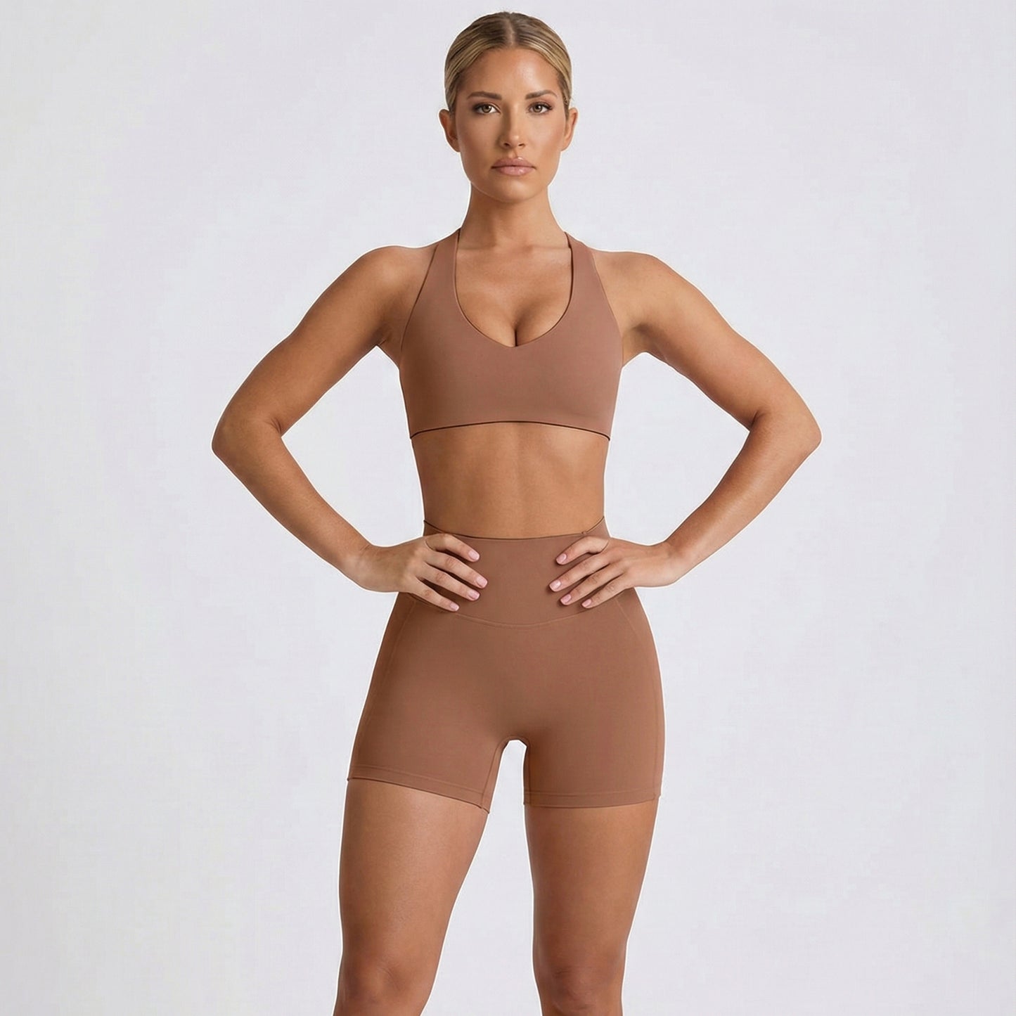 Woman wearing a coco dew heart flex bra and shorts set on a light gray background