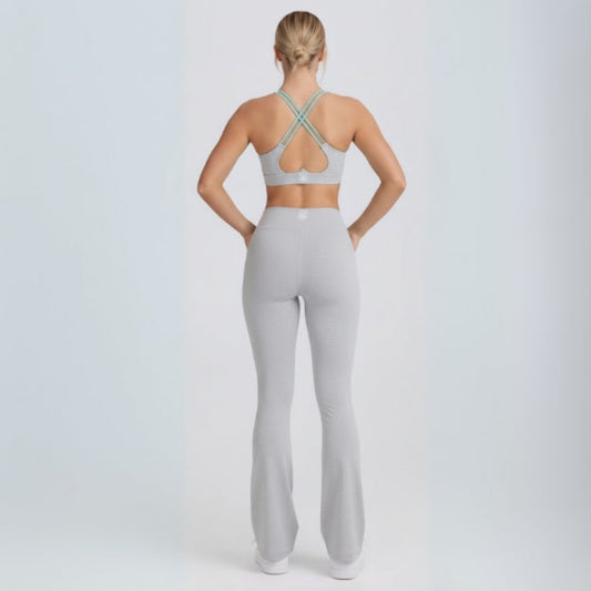 Person wearing a gray sports bra and Dew Flow fit flares leggings set on a white background