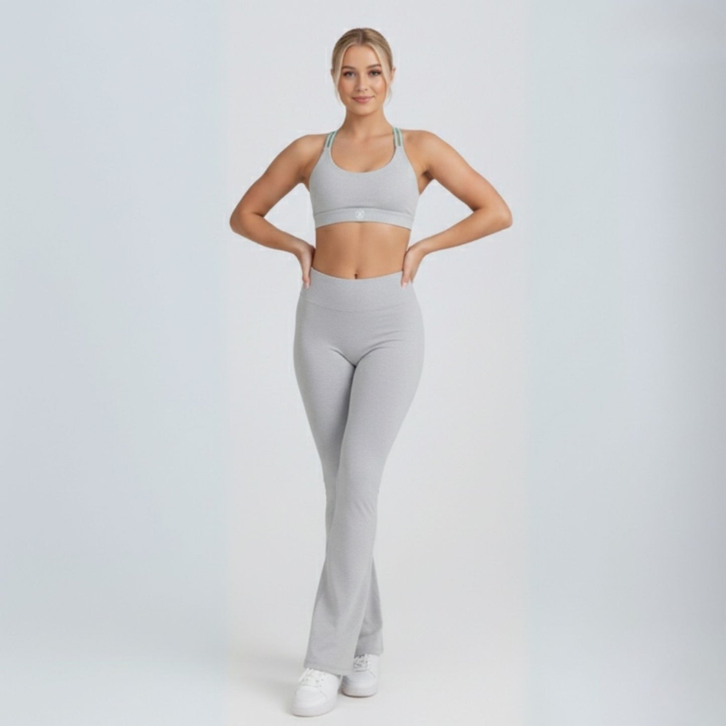 Woman wearing a gray Dew Flow fit flares athletic outfit on a white background