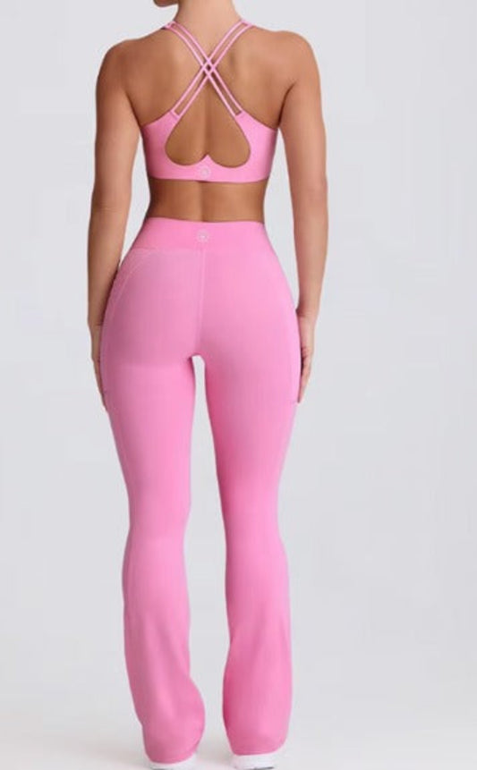 Pink Dew Flow fit flares athletic outfit with open-back top and leggings on a white background
