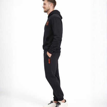 Person wearing a black hoodie and pants with orange text on a white background