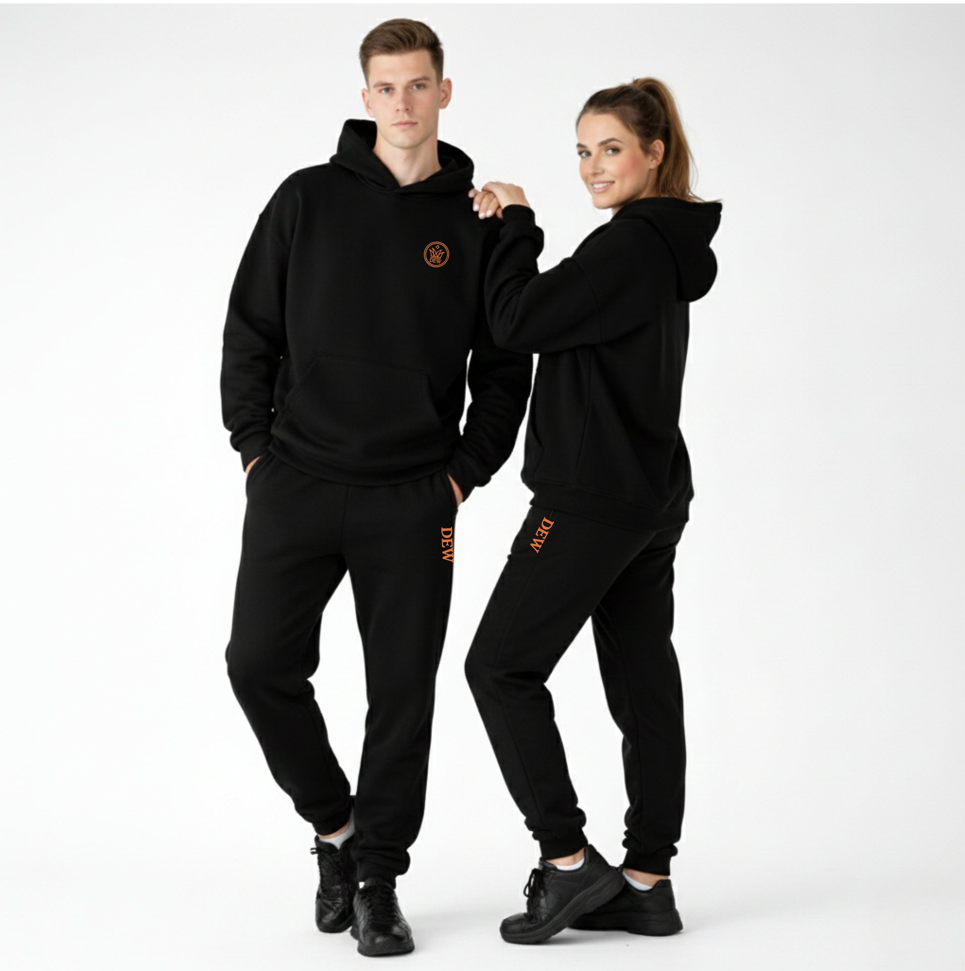 Two people wearing matching black outfits with a logo on a white background