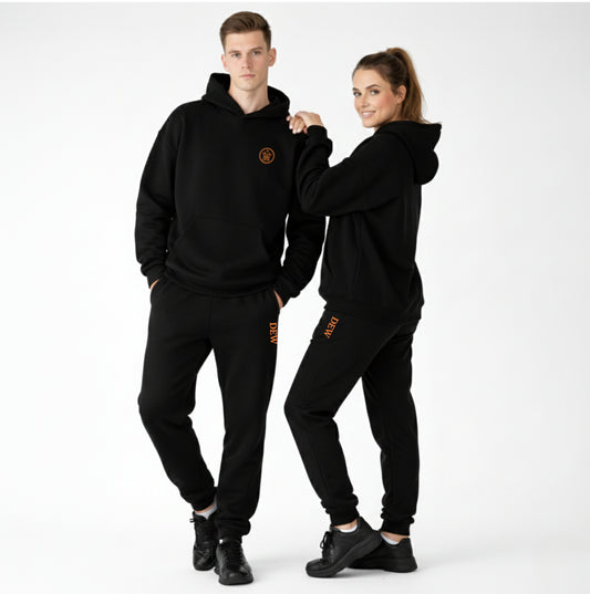 Two people wearing matching black outfits with a logo on a white background
