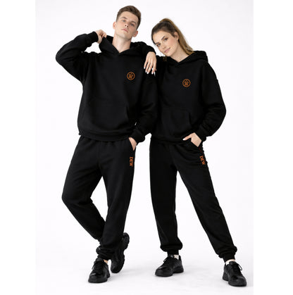 Two people wearing matching black outfits with logos on a white background