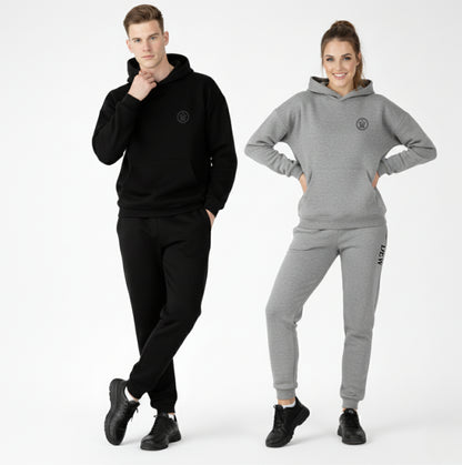 Man and woman wearing black and gray tracksuits with a logo on a white background