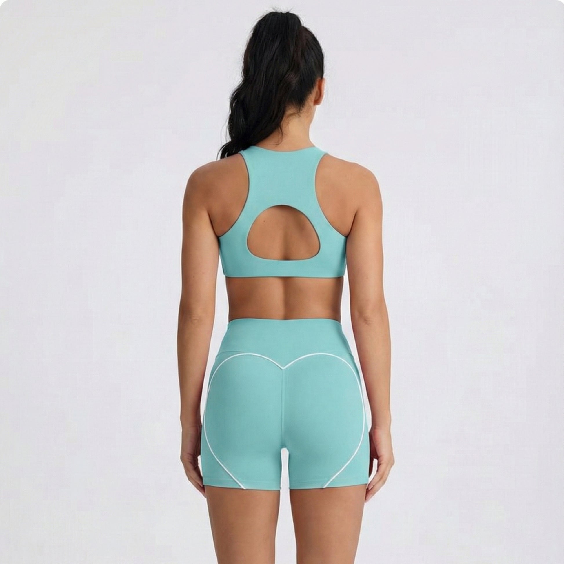 Person wearing a Dew mint sports bra and dew curve shorts set on a white background