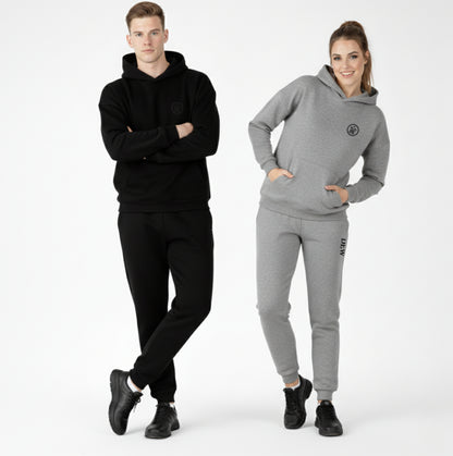 Man and woman wearing black and gray tracksuits on a white background