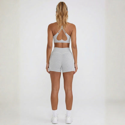 Person wearing a dew gray sports bra and dew curve shorts set on a white background