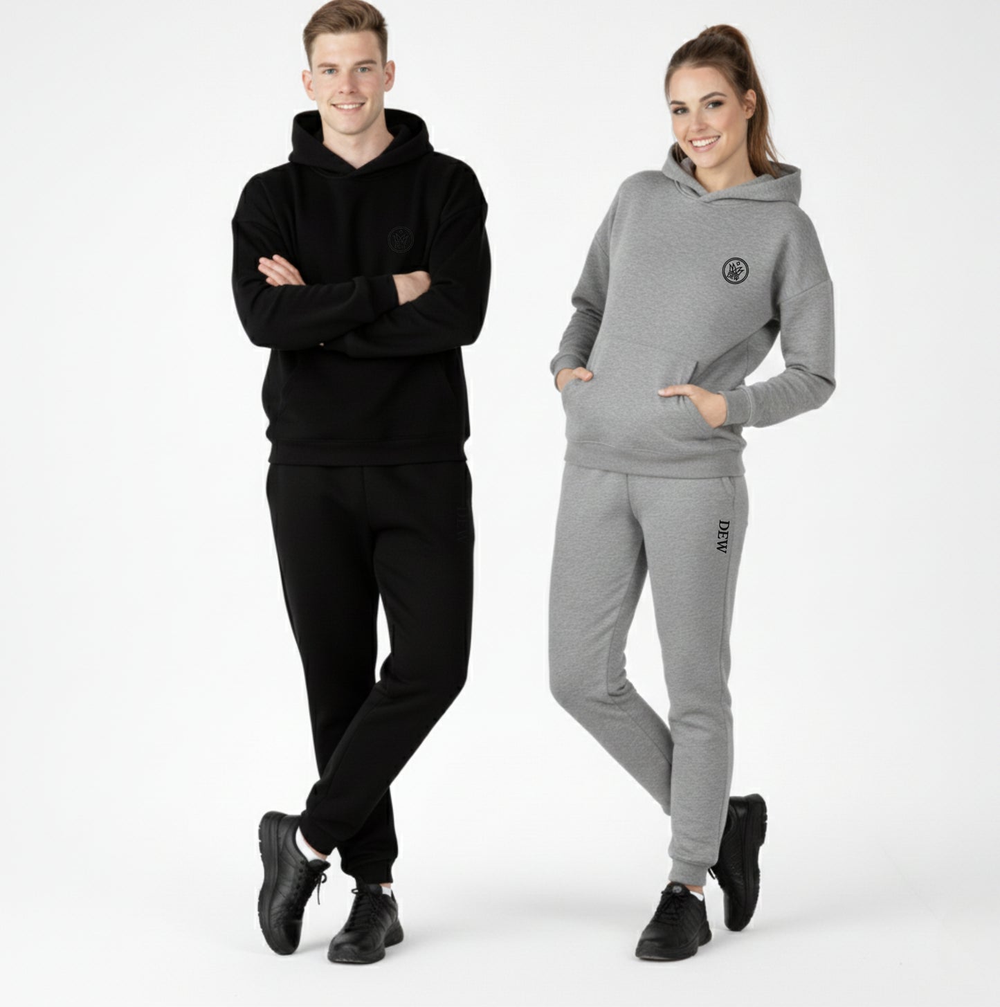 Two people wearing black and gray tracksuits on a white background