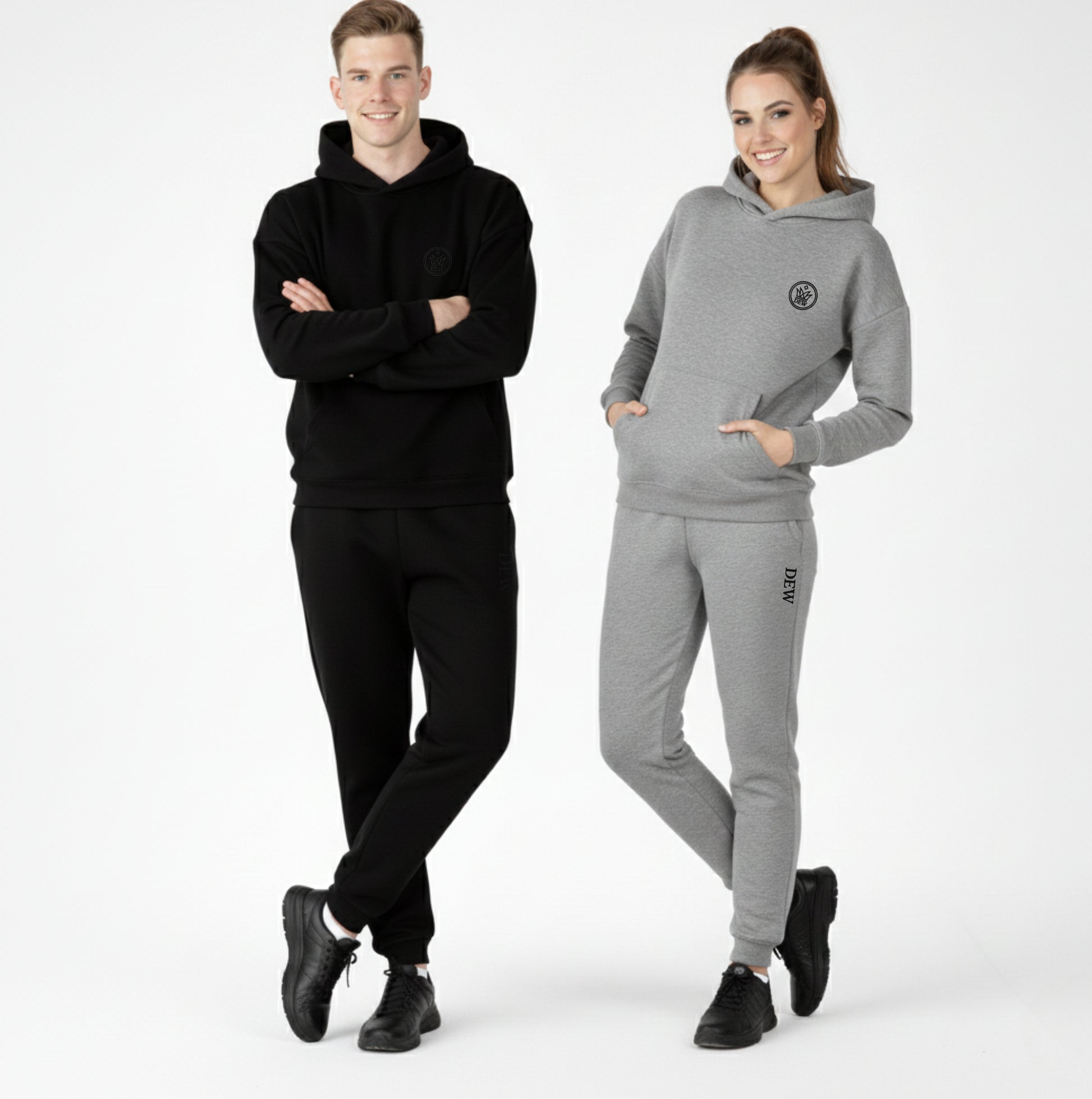Two people wearing black and gray tracksuits on a white background