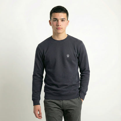 Man wearing a dark gray long-sleeve shirt with a small logo on a white background