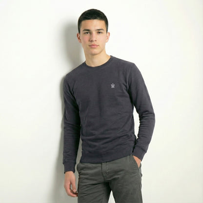 Man wearing a dark gray long-sleeve shirt against a white background