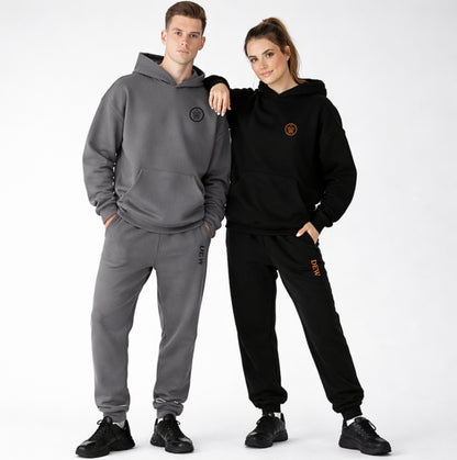 Two people wearing gray and black tracksuits with a brand logo on a white background