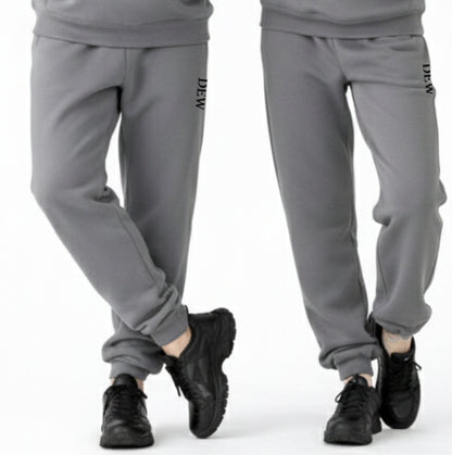 Gray sweatpants with brand logo worn by a person on a white background