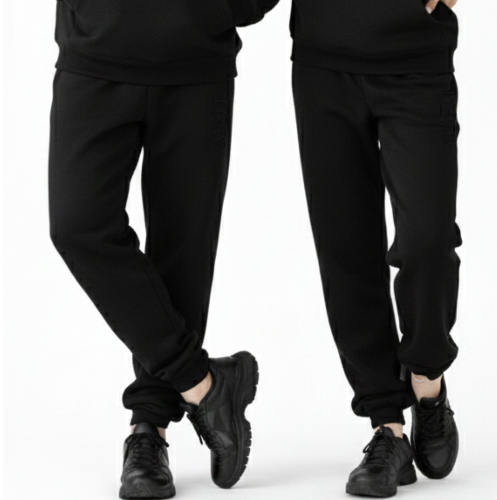 Two pairs of black pants worn by people on a white background
