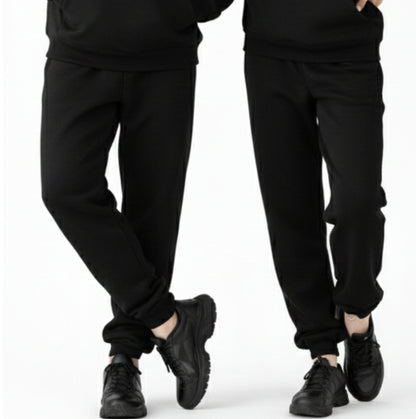 Two pairs of black pants worn by people on a white background