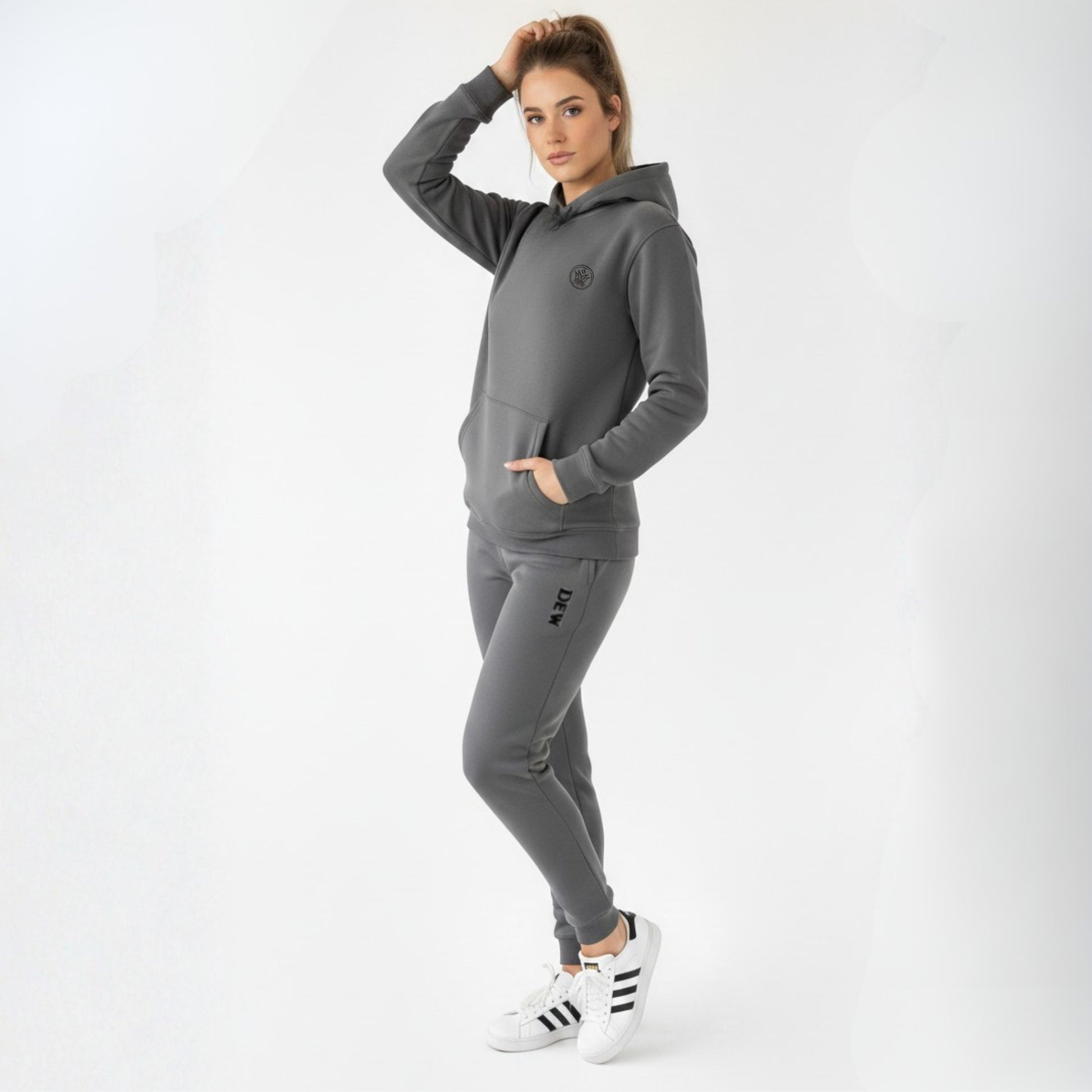 Woman wearing a gray tracksuit with a brand logo on a white background