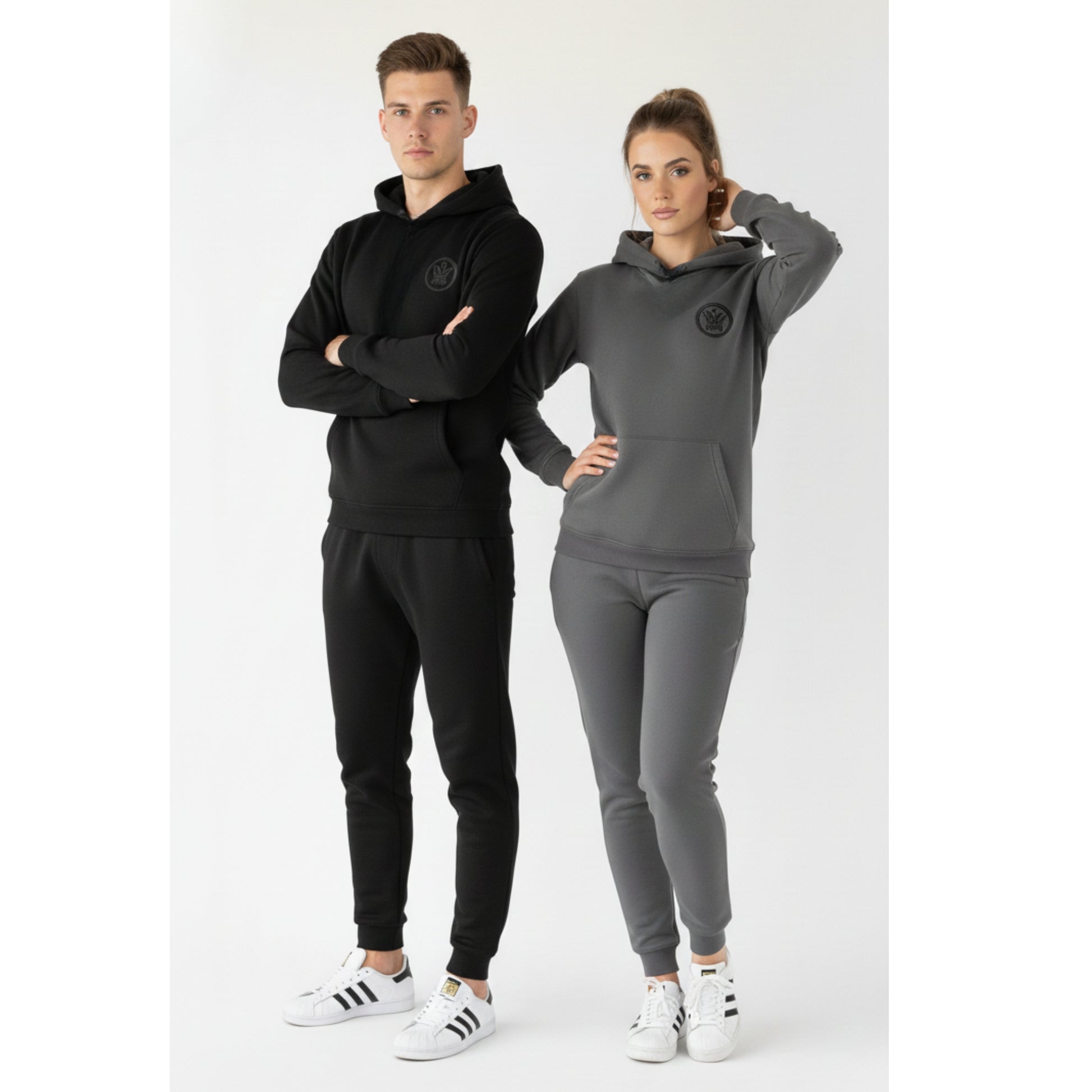 Two people wearing black and gray tracksuits with a brand logo on a white background