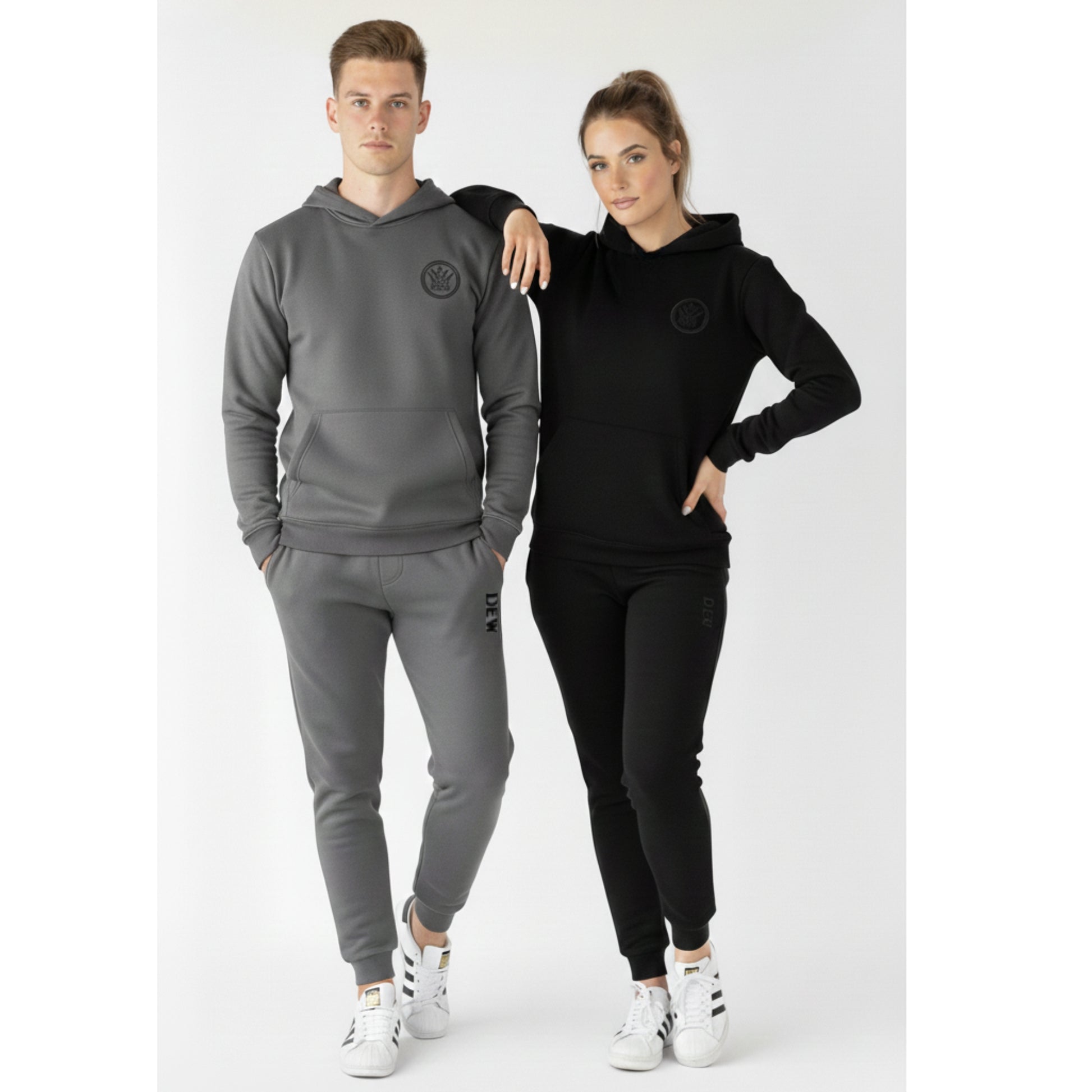 Two people wearing gray and black tracksuits with a logo on a white background
