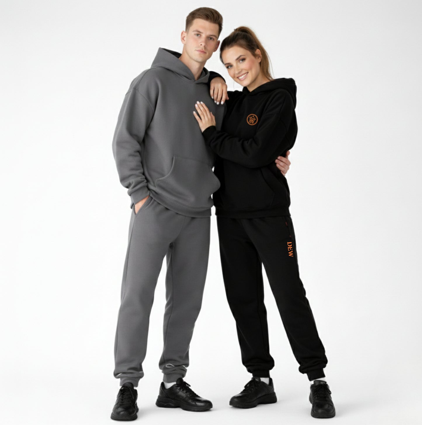 Two people wearing gray and black tracksuits on a white background