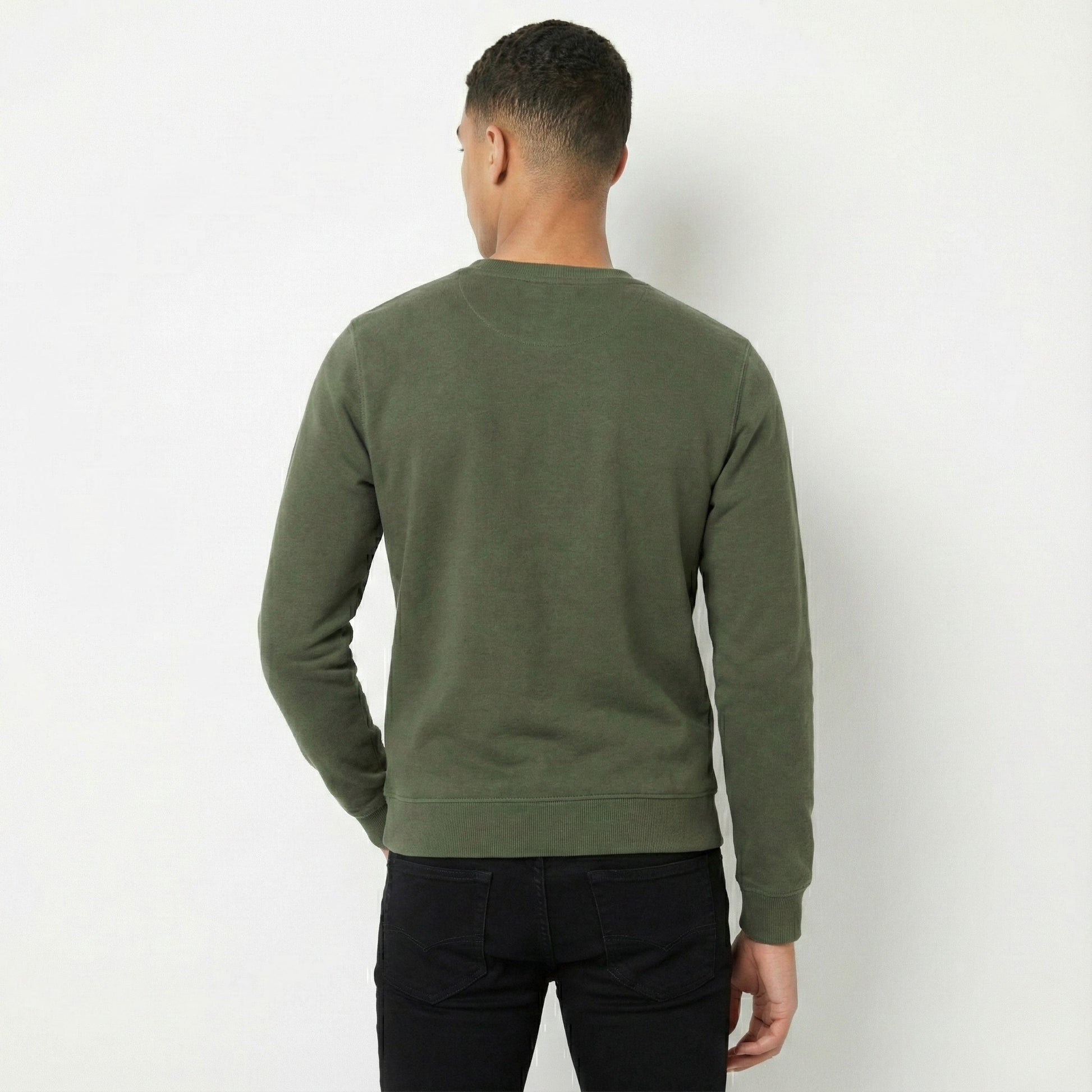 Person wearing a green sweater from behind on a white background