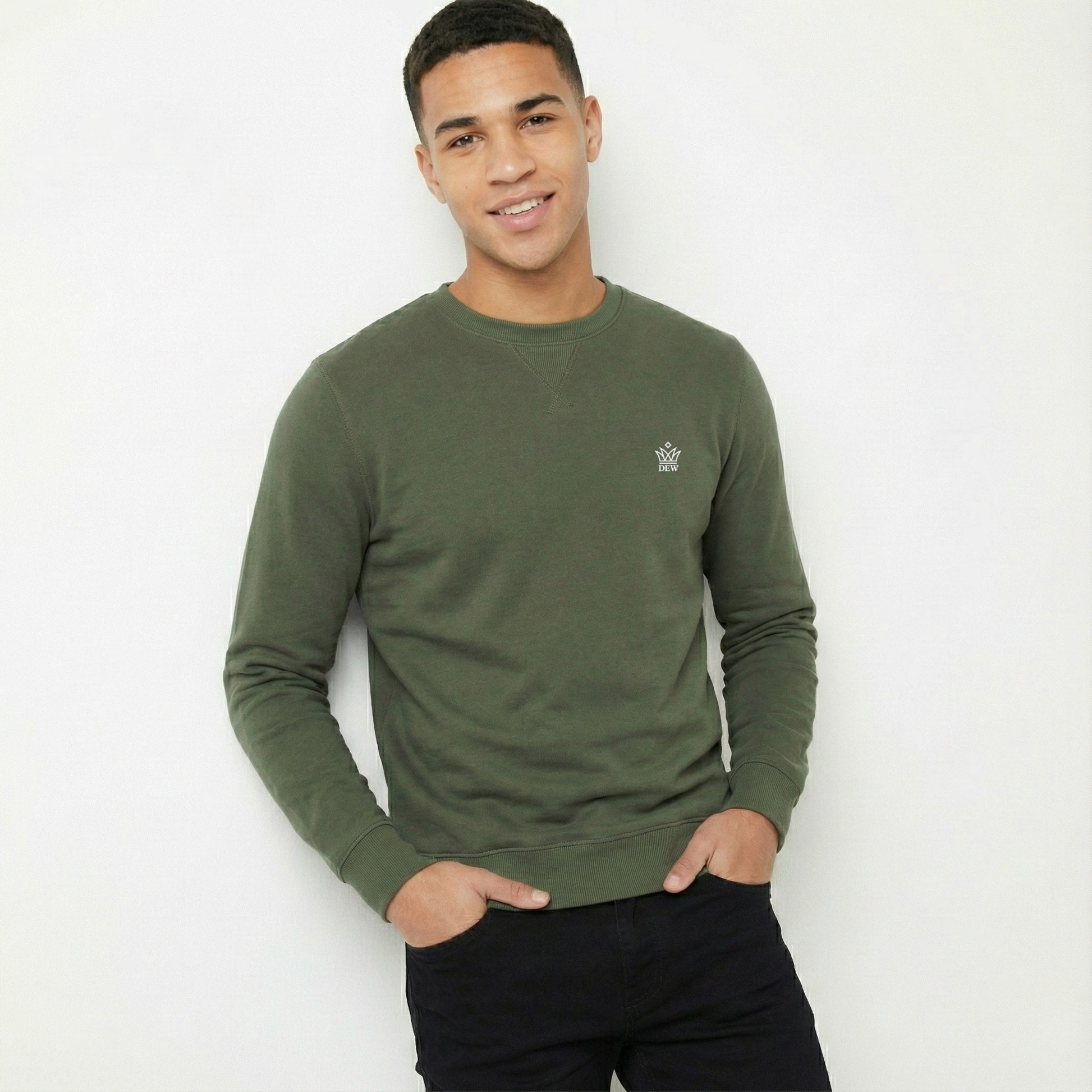 Man wearing a green sweatshirt with a small logo on a white background