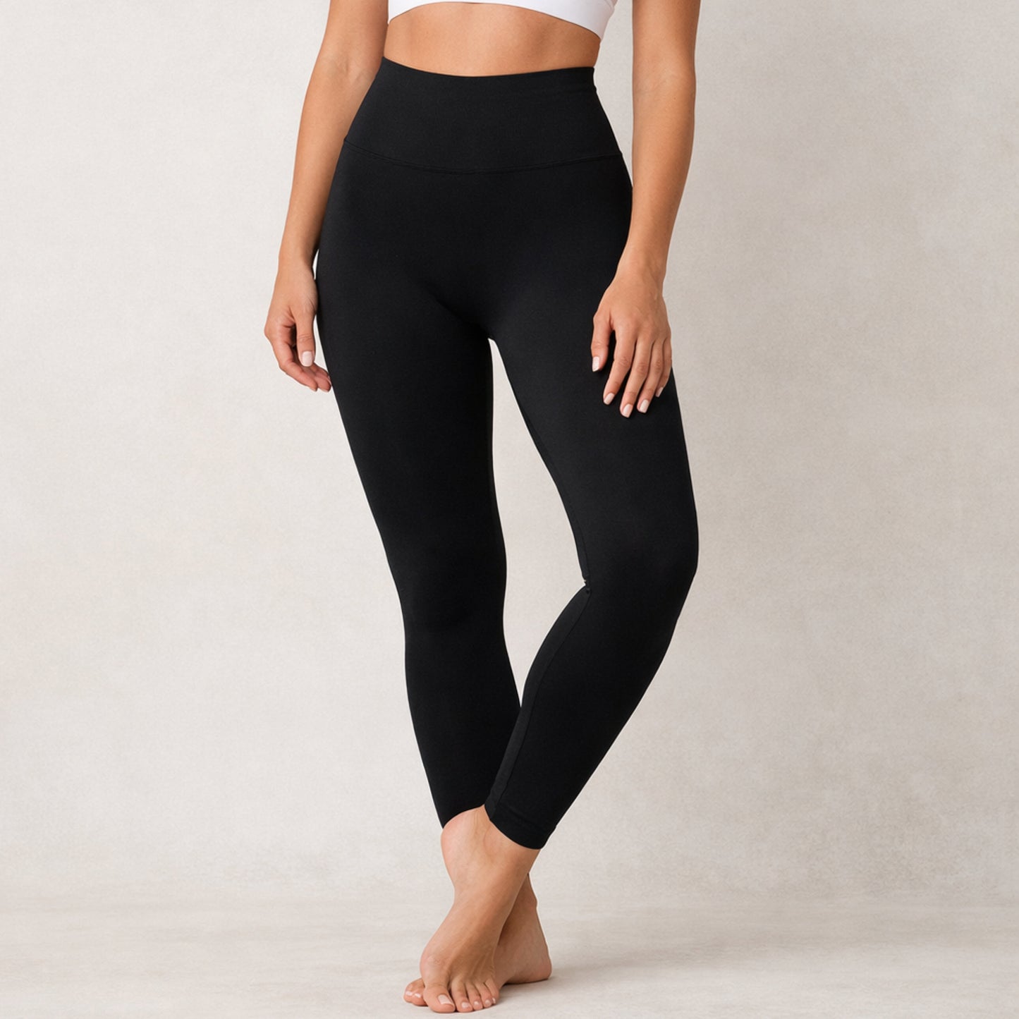 Person wearing dew black leggings on a plain background
