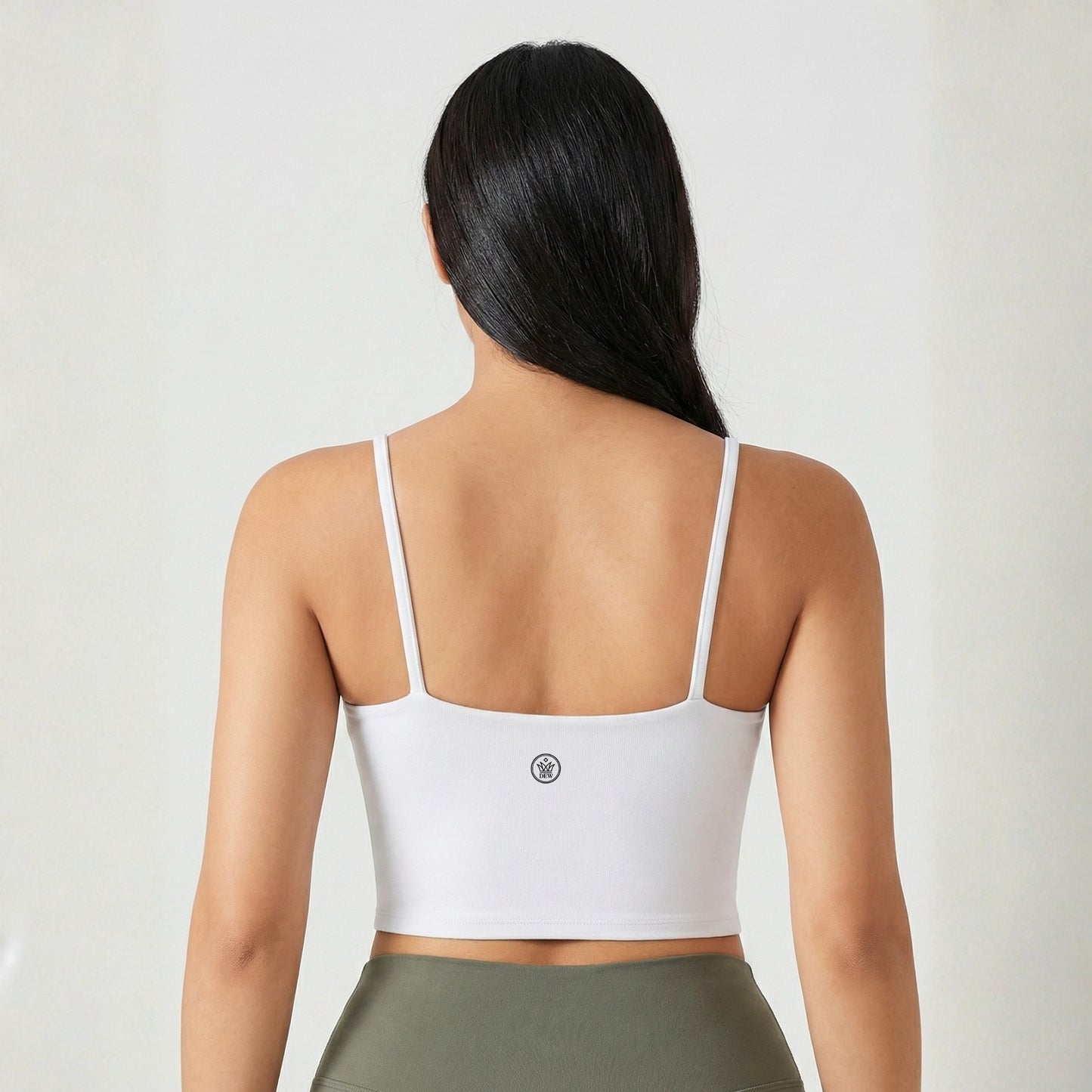 Person wearing a white sports bra with a visible brand logo on a plain background