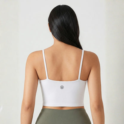 Person wearing a white sports bra with a visible brand logo on a plain background