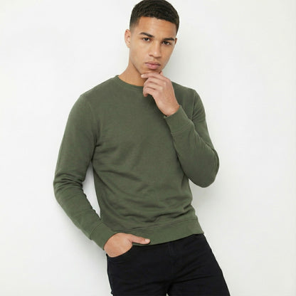 Man wearing a green sweater against a white background
