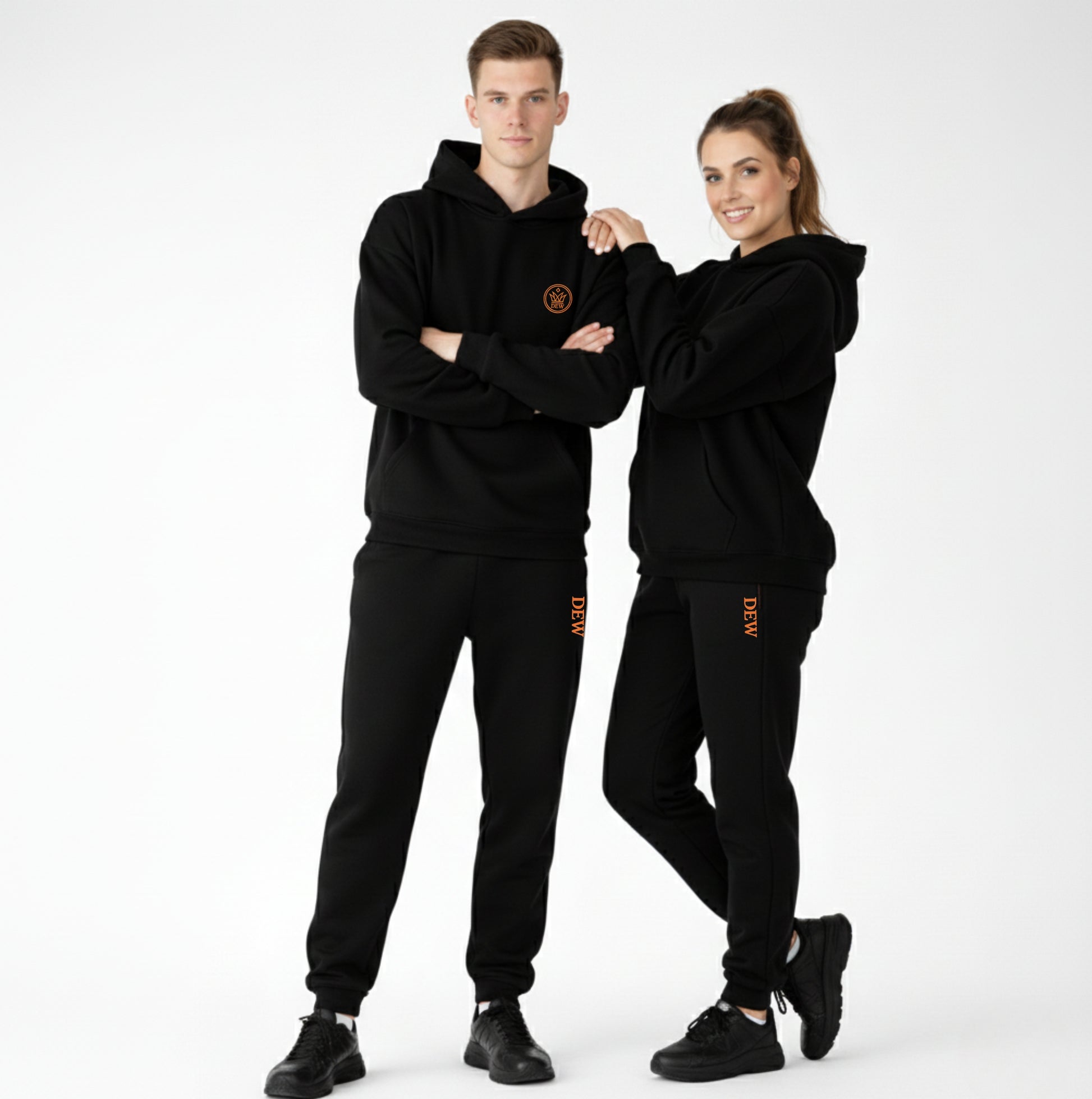 Two people wearing matching black tracksuits with a logo on a white background