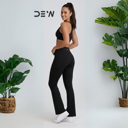 Woman wearing black seamless sports bra and Flow Fit Flare leggings set. Minimalist studio shot highlighting fit and DEW logo.