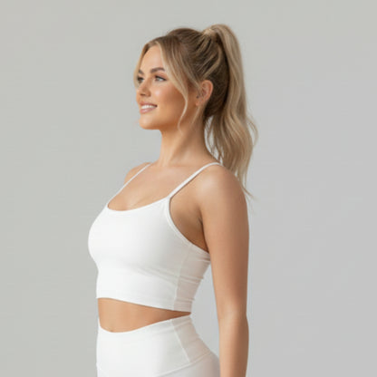 Woman wearing a DEW™ Balance Sports Bra and pants against a plain background