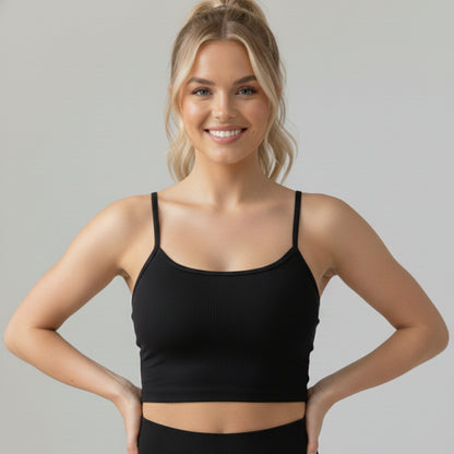 Woman wearing a black DEW™ Balance Sports Bra against a gray background