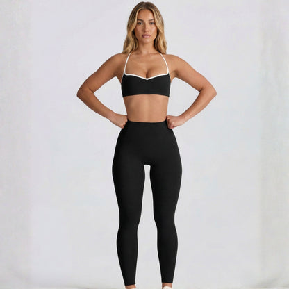Woman wearing a black DEW Elevate sports bra and leggings on a white background