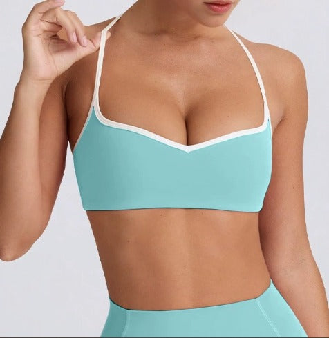 Person wearing a light blue DEW Elevate sports bra and leggings on a white background