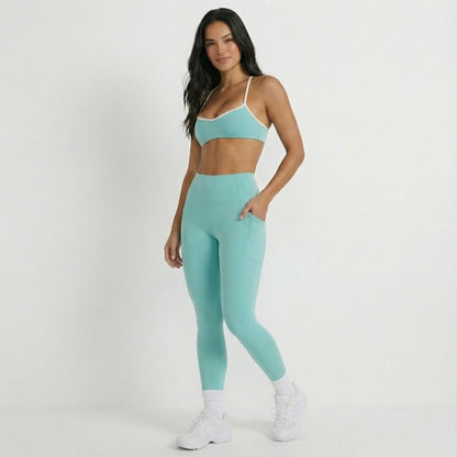 Woman wearing a DEW Elevate bra and athletic outfit on a white background