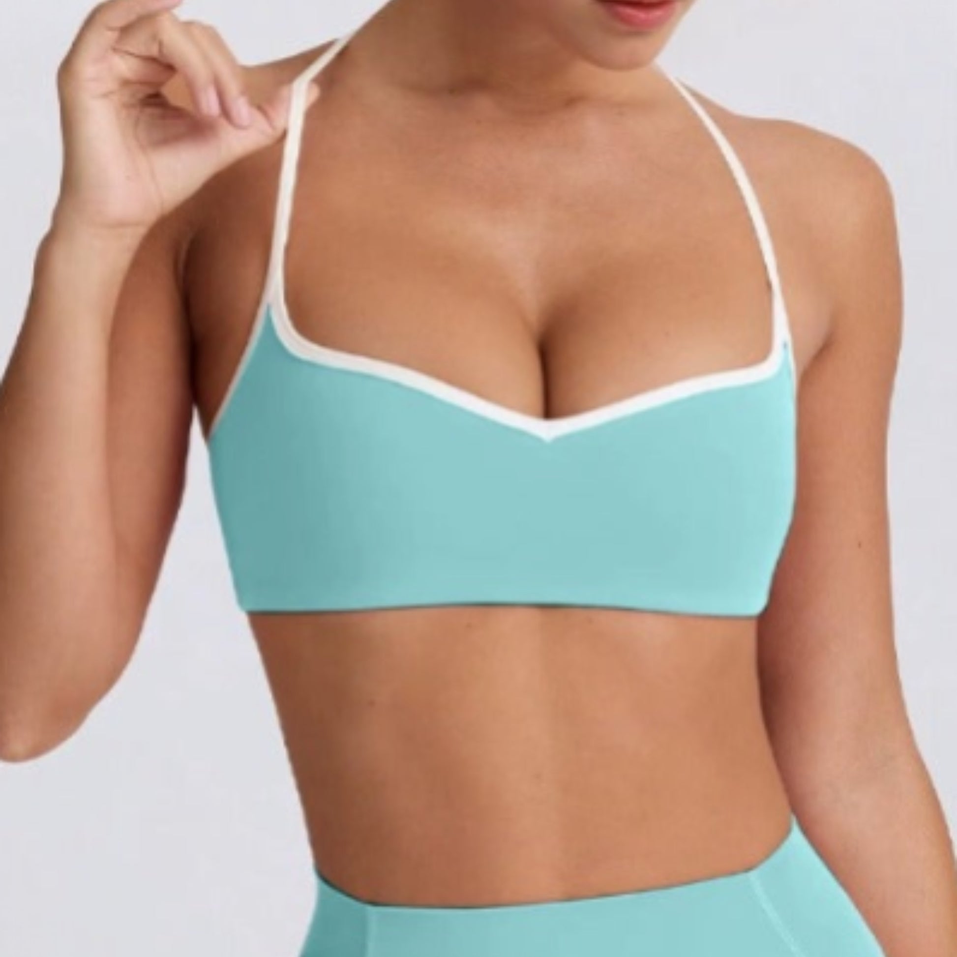 Person wearing a DEW Elevate bra in mint on a plain background