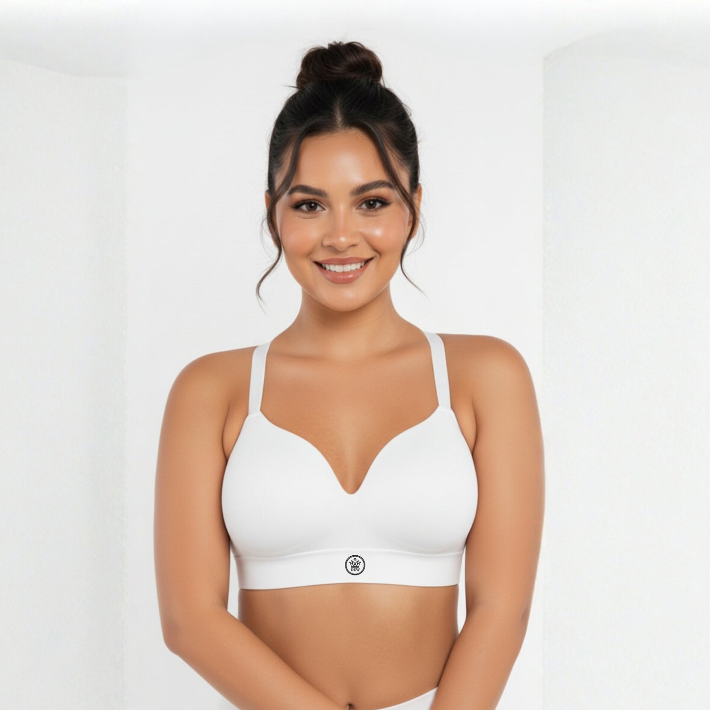 Woman wearing a white DEW Seamless Sculpt Bra on a plain background