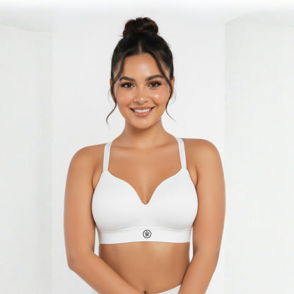 Woman wearing a white DEW Seamless Sculpt Bra on a plain background