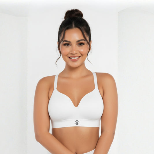 Woman wearing a white DEW Seamless Sculpt Bra on a plain background