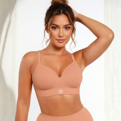 Woman wearing a brown DEW Seamless Sculpt Bra and leggings on a white background