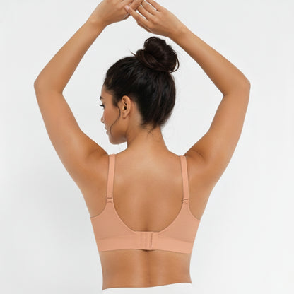 Woman wearing a beige DEW Seamless Sculpt Bra on a white background