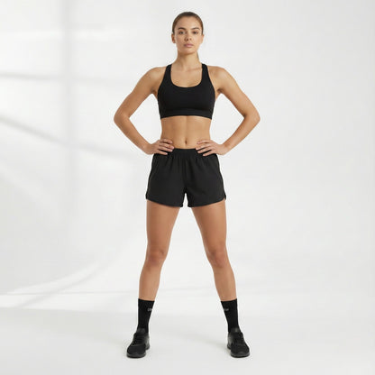 Person wearing Dew 100% Bamboo socks and a black sports bra and shorts set on a white background