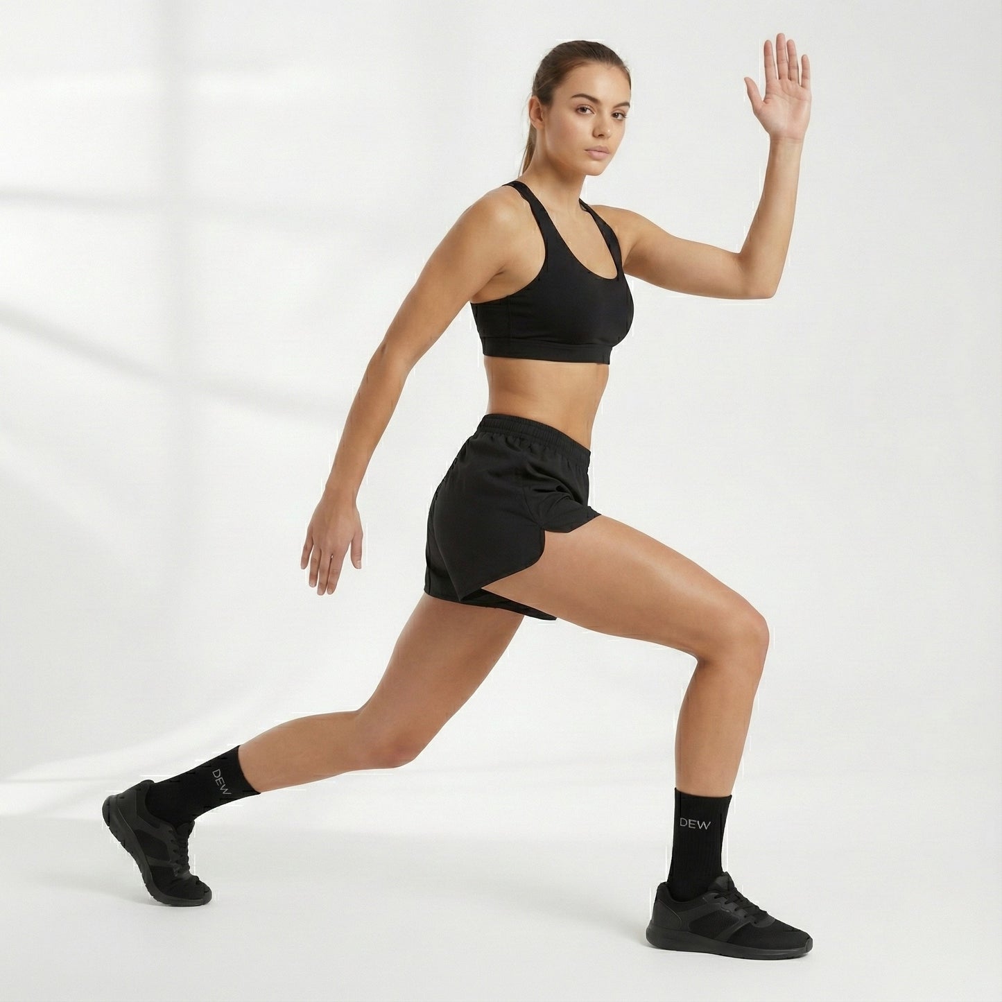 Woman in black athletic wear and Dew 100% Bamboo socks posing against a white background