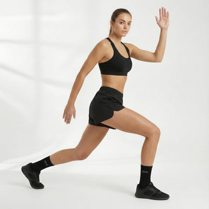 Woman in black athletic wear and Dew 100% Bamboo socks posing against a white background