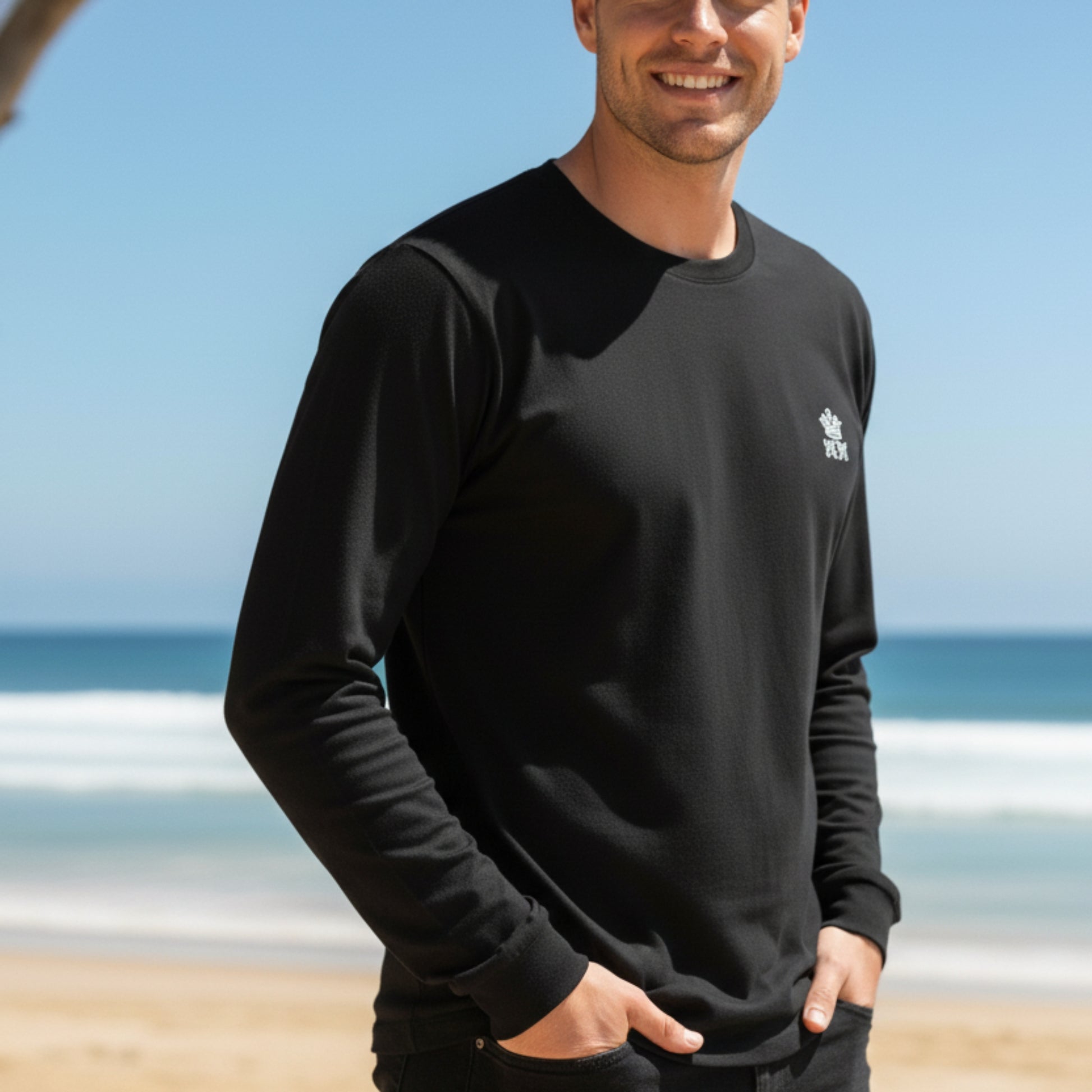 Man wearing a  Dew 100% Cotton black sweatshirt with a logo on a beach